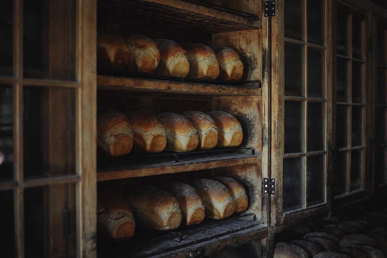 Shelves of baked loaves in a wooden cabinet, used as reference craft photography